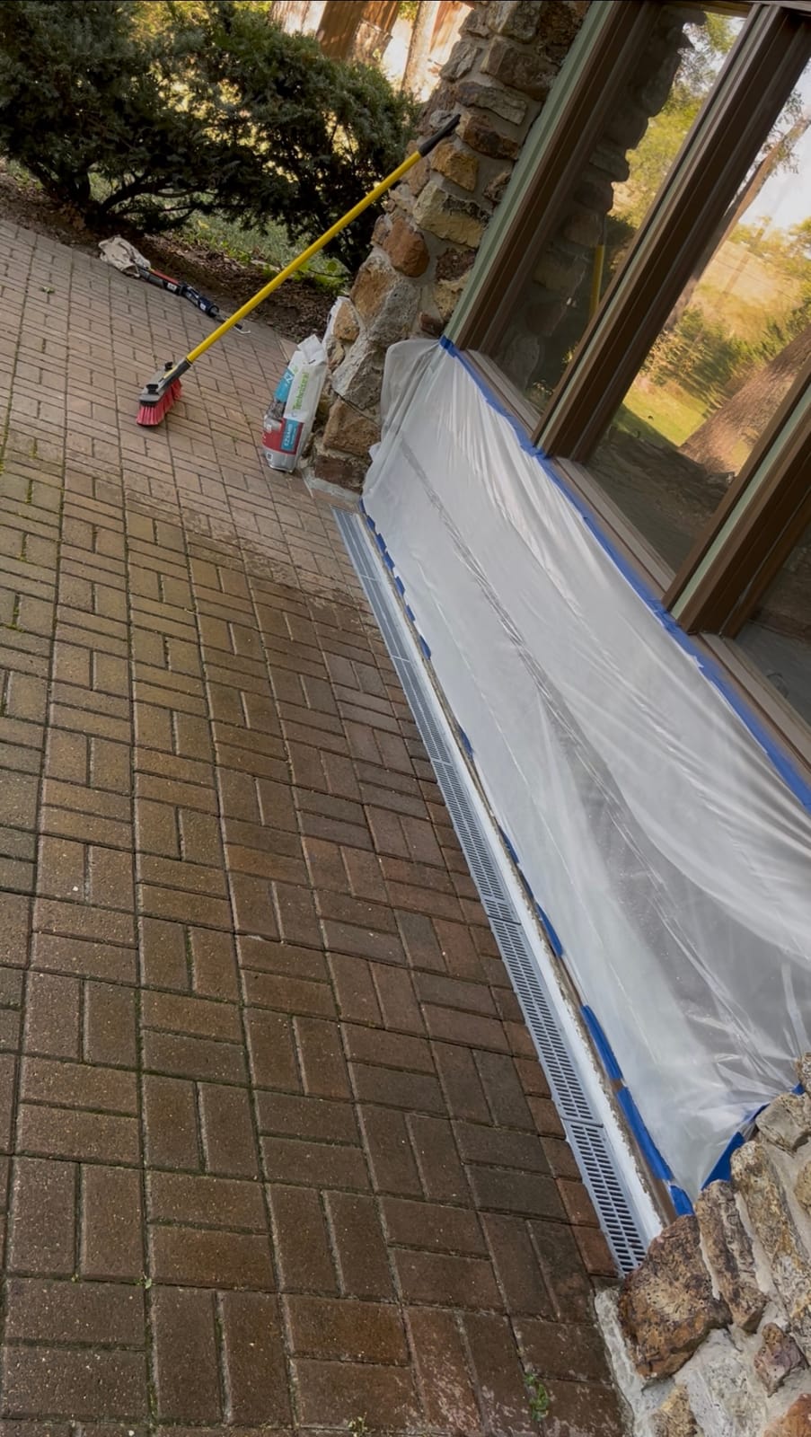 Finished channel drain running flush along the foundation with pavers relaid beside it